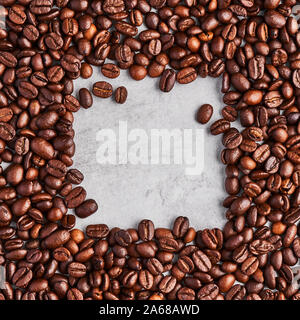 Coffee beans isolated on a grey concrete background. Coffee frame. Top view. Copy space. Design element. Square crop. Stock Photo