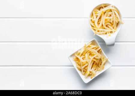Preserved mung sprout in bowl on white table. Top view. Stock Photo