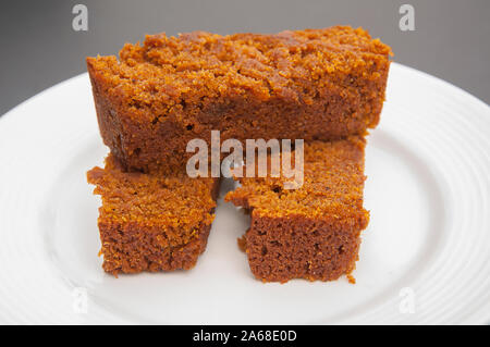 Slices of pumpkin bread on white plate in this fall food of baked goodies.  Three pieces of this homemade bread are stacked after being freshly baked. Stock Photo