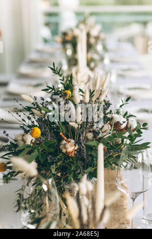 Table decoration for a ceremony or celebration. Beautiful flowers on the table in rustic style. Stock Photo