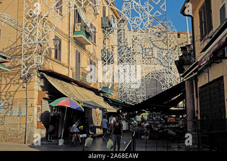 Shoppers exiting outdoor market at the the Mercato di Ballaro. Palermo, Sicily, Italy. Photographed on July 31, 2019. Stock Photo