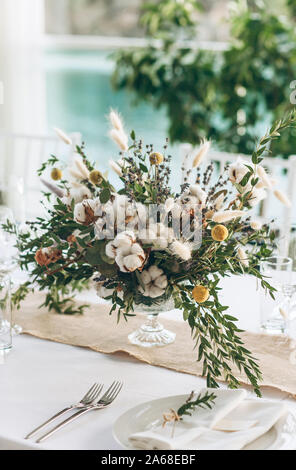 Table decoration for a ceremony or celebration. Beautiful flowers on the table in rustic style. Stock Photo