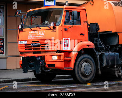 Moscow, Russia - October 19, 2019: Orange irrigation sweepers truck stand on the tram tracks. Moscow coat of arms. Cityscape. Stock Photo