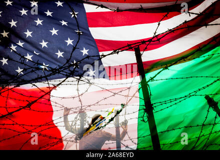 Man at barbed wire, razor wire fence with USA flag and Mexican flag overlayed. Immigration, border fence, Mexican border... concept Stock Photo