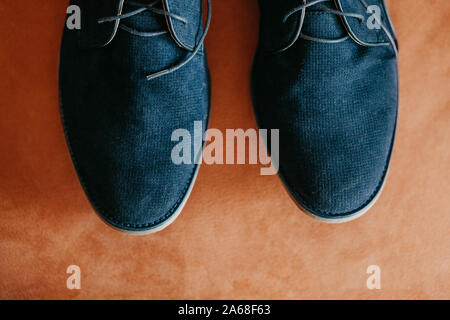 Closeup of dark blue nubuck new shoes on a coral or orange colored surface. Stock Photo