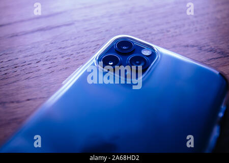 Paris, France - Oct 4, 2019: Close-up macro image of the latest Apple Computers triple-lens iPhone 11 Pro with transparent Clear Case case - blue color cast Stock Photo