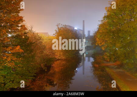 An autumn morning on the Leeds Liverpool Canal in Leeds, with Canal Mills in the distance Stock Photo