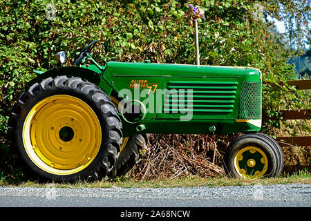 A side view of an antique Oliver farm tractor parked for people to view along a roadway in British Columbia Canada. Stock Photo