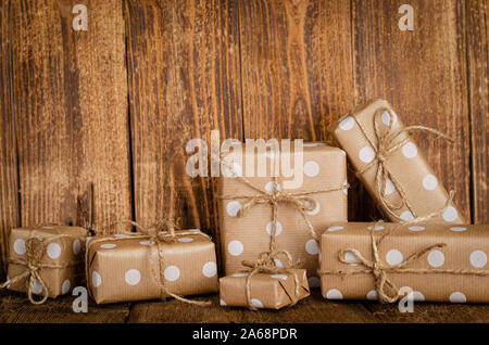 Gift or present boxes wrapped in craft paper on wooden background. Copy space. Stock Photo