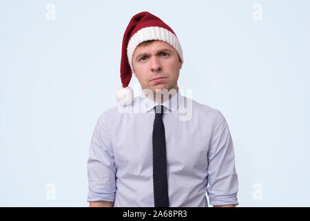 man wearing red christmas cap is upset because he is tired of working in office. Stock Photo