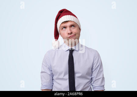 man wearing red christmas cap is upset because he is tired of working in office. Stock Photo