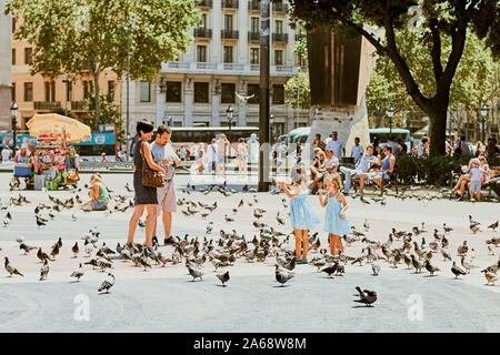 Barcelona, Spain - August 08, 2011: Placa de Catalunya (Catalonia Square) in Barcelona. Two little sisters with parents. Stock Photo