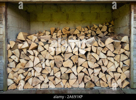 Wood logs piled high in a log store Stock Photo