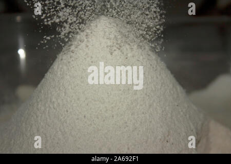 Cloud of icing sugar and sifted almond flour in the form of rain falling to flour volcano Stock Photo