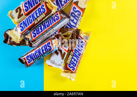 OCTOBER 22 2019 NY USA: Snickers snack bar in mini candy bars maple almond butter candy ang almond butter candy bar on blue and yellow isolated backgr Stock Photo