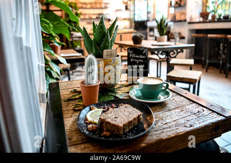 Berlin, Germany. 24th Oct, 2019. Coffee, cake and houseplants are all on one table at Café´ 'The Greens'. (To Korr ' Green and chic: Young city dwellers let plant market boom' of 25.10.2019) Credit: Britta Pedersen/dpa-Zentralbild/dpa/Alamy Live News Stock Photo