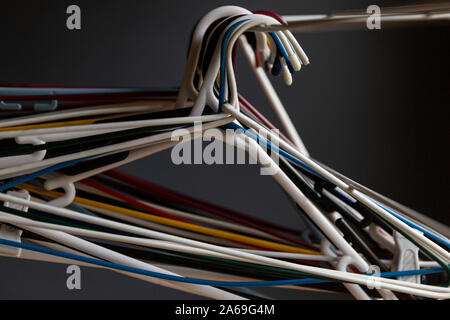 Multicoloured coat hanging placed together on domestic clothing rack. Stock Photo