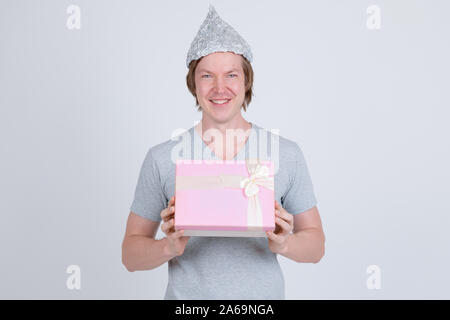 Happy young man with tin foil hat holding gift box Stock Photo