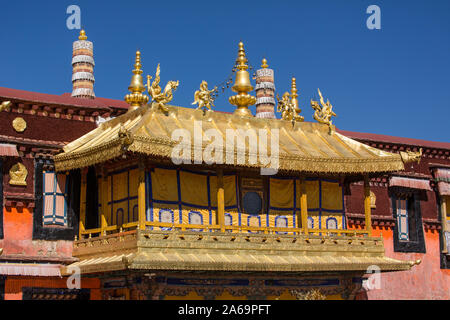 Architectural detail, statues and the gilt roof of the Jokhang Buddhist temple in Lhasa, the holiest temple Tibet.  A UNESCO World Heritage Site. Stock Photo