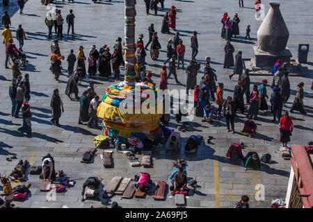 Tibetan pilgrims circumambulate around and prostrate themselves in front of the Jokhang Buddhist Temple in Barkhor Square in Lhasa, Tibet. Stock Photo