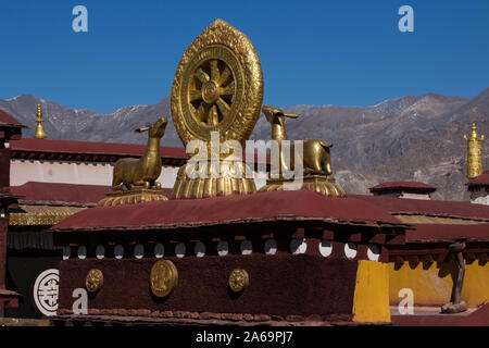 The Dharma Wheel and deer statues are Buddhist symbols on the top of the Jokhang Temple in Lhasa, Tibet.  A UNESCO World Heritage Site. Stock Photo