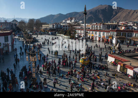 Tibetan pilgrims circumambulate around and prostrate themselves in front of Tibet's holiest Jokhang Temple in Barkhor Square in Lhasa, Tibet. Stock Photo