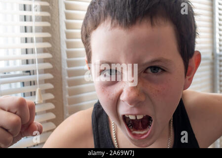 Agressive young boy venting anger with a closed fist. Stock Photo