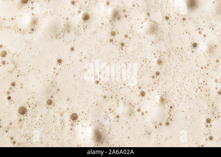 Macro shot Beer foam bubbles  texture background. Craft beer flowing foam with sparkling bubbles. Beer foam texture close up. Stock Photo