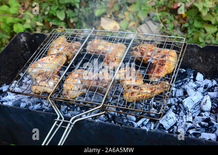 BBQ chicken wings on smoking grill over hot coals. Stock Photo