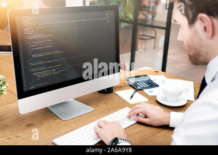 Programmer working on code in office. Man working on desktop. Stock Photo
