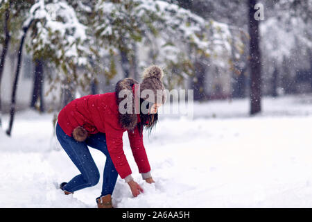 Girl playing with snow. Wintertime. Happy woman holds snowball in hands. Stock Photo