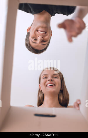 young couple looking inside a cardboard box Stock Photo