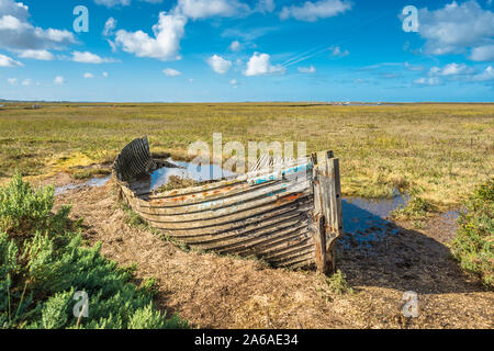 Rustic old boat left to decay on Salt Marshes between Blakeney and Cley next the sea coastal villages on North Norfolk Coast, East of England, UK. Stock Photo