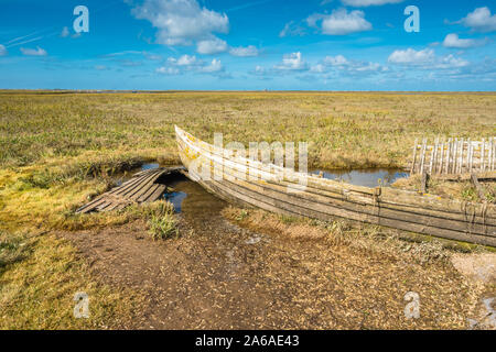 Rustic old boat left to decay on Salt Marshes between Blakeney and Cley next the sea coastal villages on North Norfolk Coast, East of England, UK. Stock Photo