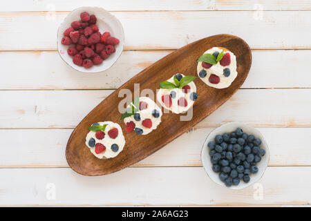 Delicious cupcakes with berries and fresh mint on wooden table Stock Photo
