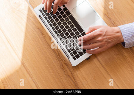 Businessman working on laptop, top view on male hands using laptop Stock Photo