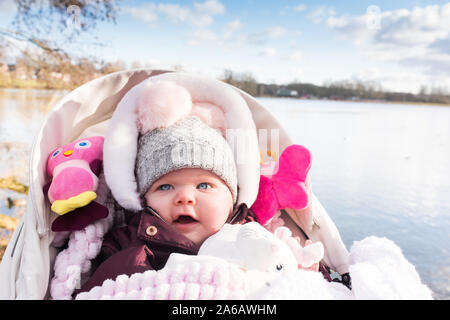 A gorgeous happy little baby 18 months old in a pram by Westport Lake in Stoke on Trent, Staffordshire Stock Photo