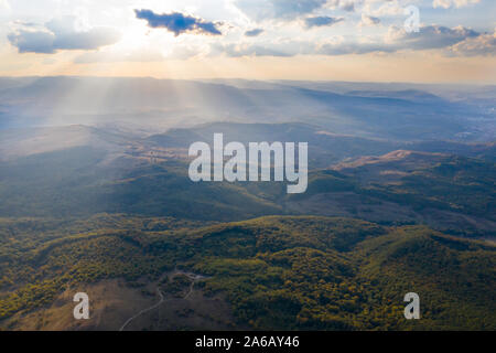 Aerial, drone view of endless lush pastures and mountains with green forests and meadows. Stock Photo