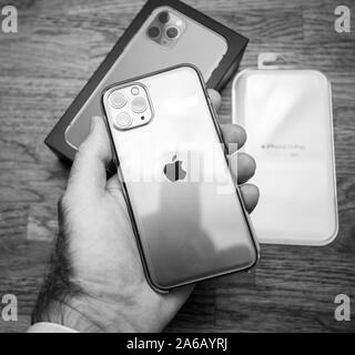 Paris, France - Oct 4, 2019: Close-up macro image of the latest Apple Computers triple-lens iPhone 11 Pro with green color transparent Clear Case case - black and white image Stock Photo