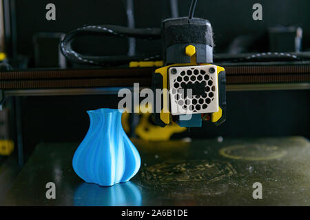 Modern 3d printer with printed three dimentional model of vase. Hand holding filament in the foreground Stock Photo
