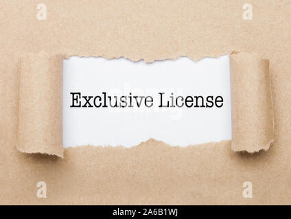 Exclusive License concept text appearing behind torn brown paper envelope Stock Photo