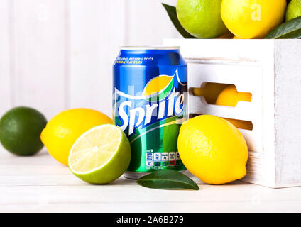 LONDON, UK - APRIL 12, 2017: Aluminium can of Sprite drink on wooden background with lemons and limes. Sprite is lemon-like flavored soft drink produc Stock Photo
