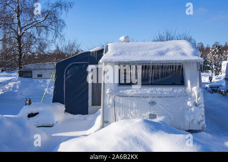 Snowy and icy caravan at a campsite Stock Photo