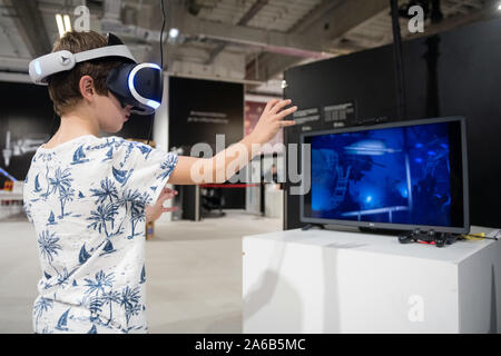 BRATISLAVA, SLOVAKIA - OCT 25, 2019: Young boy exploring computer simulation using virtual reality glasses at the mall in Bratislava, Slovakia Stock Photo