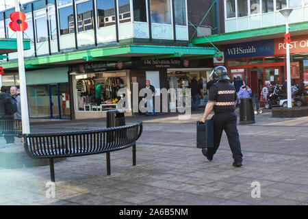 A cash in transit driver in stab proof vest and helmet collects or delivers cash to a business in the town, Loomis Armoured car, van driver Stock Photo