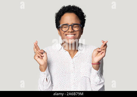 Head shot African American woman crossing fingers, wishing good luck Stock Photo