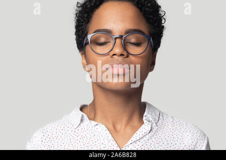 Head shot calm African American girl breathing deep, meditating Stock Photo