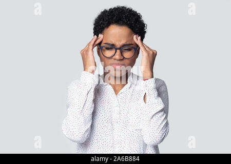 Head shot unhappy African American woman massaging temples Stock Photo
