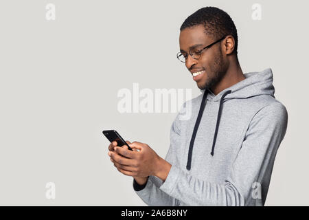 Side view smiling African American man using phone, chatting online Stock Photo