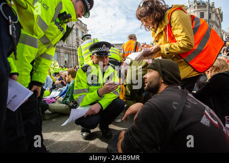 London, 10th October 2019, Extinction Rebellion demonstration and occupation of Trafalgar Square. Police move in to crowd occupying the road, to make arrests. Stock Photo
